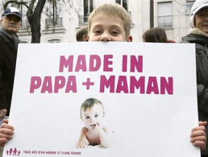 Boy carries sign protesting France's planned legalisation on same-sex marriage in Paris