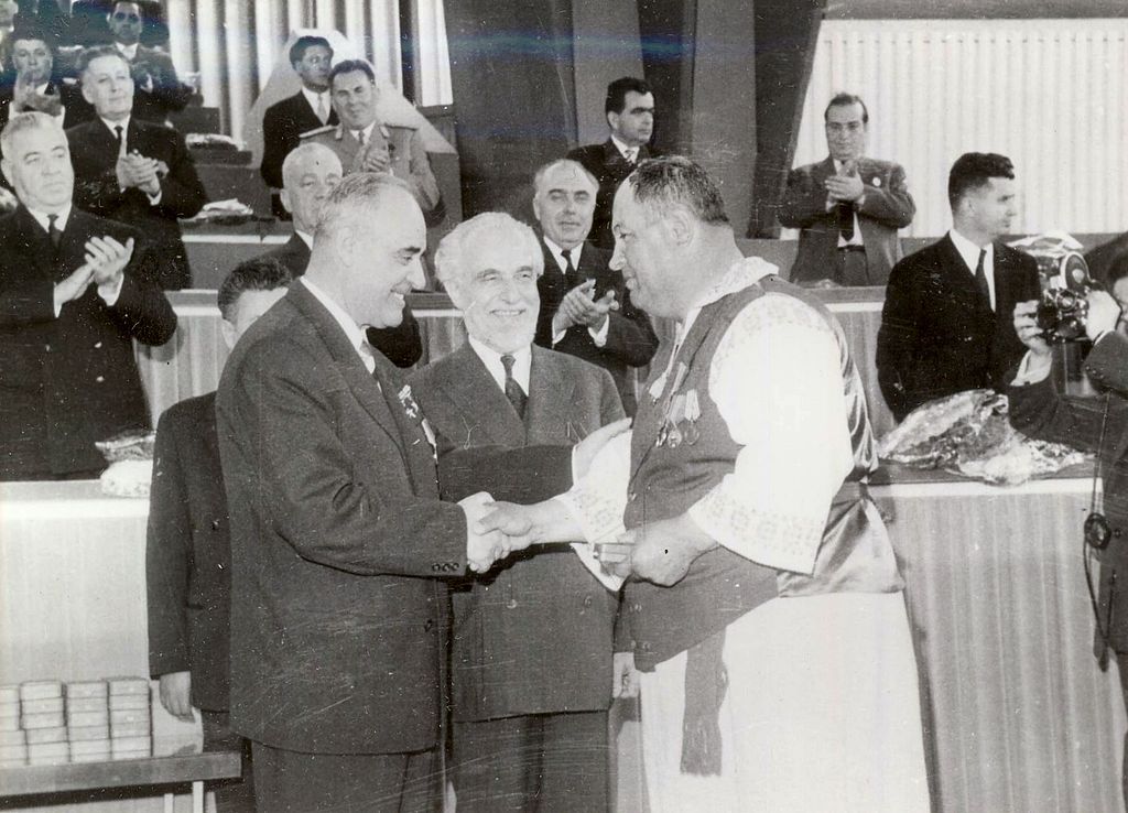 1024px-E395_End_of_collectivization_meeting_medals
